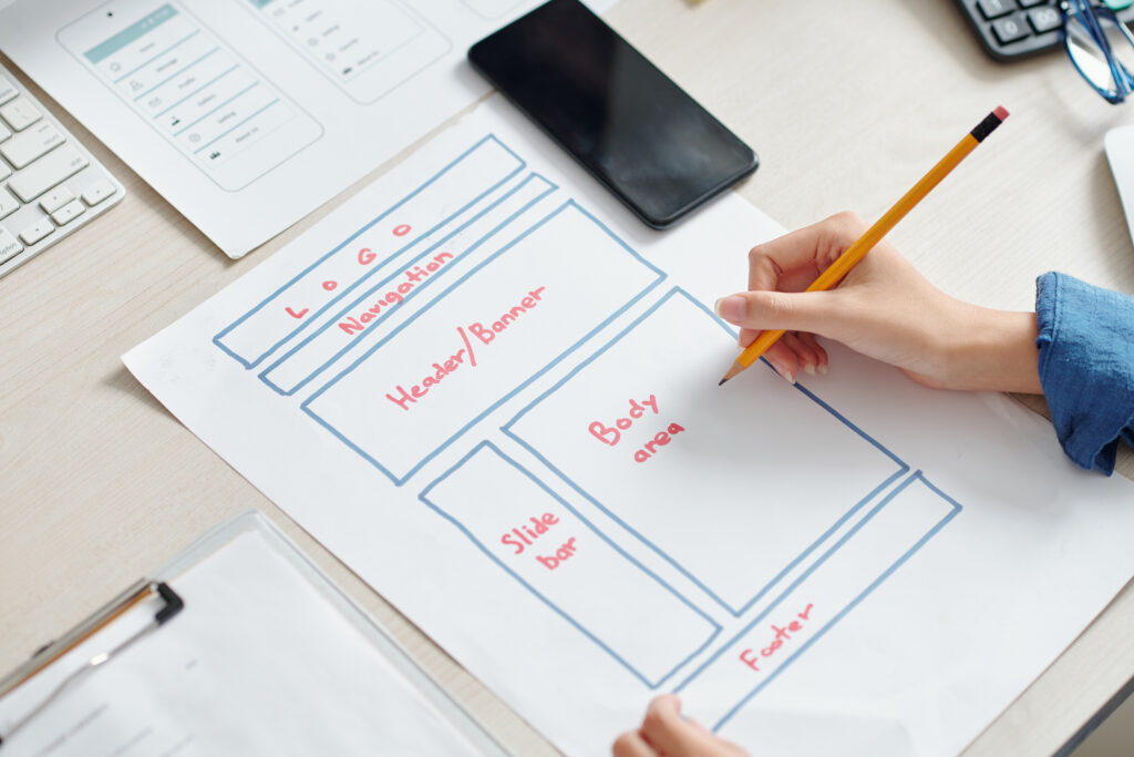 a person drawing a website on a paper