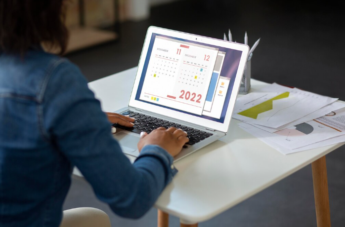 Person using laptop with calendar