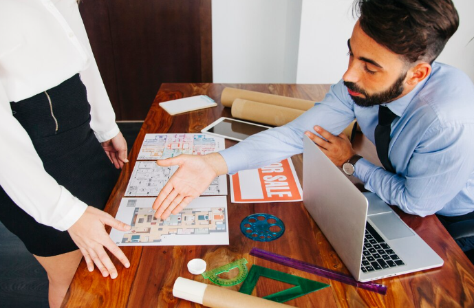 Business discussion with architectural plans and prompt