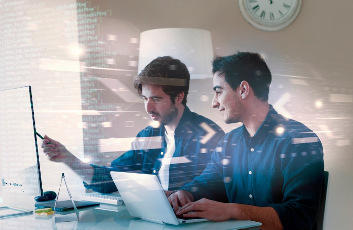 Two people collaborating with technology.