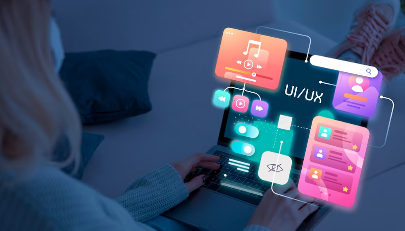 Woman using laptop with floating UI/UX design elements displayed holographically.