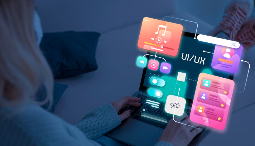 A person using a laptop with colorful floating UI/UX elements.