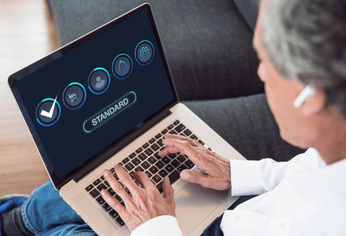 Older man working on laptop with standard system icons displayed.