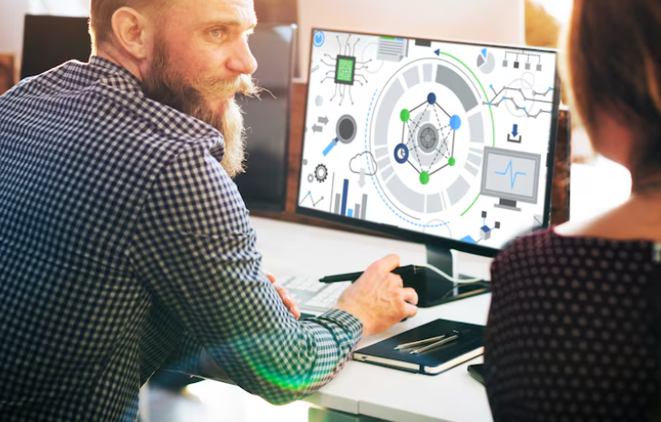 Two colleagues discussing data visualization on modern computer interface.