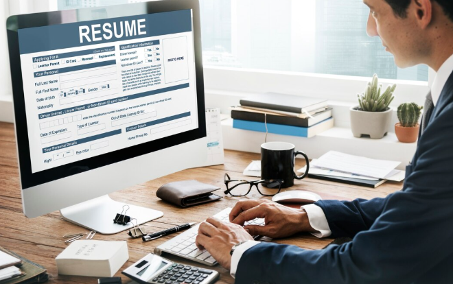 Business professional working on desktop resume form during recruitment process.