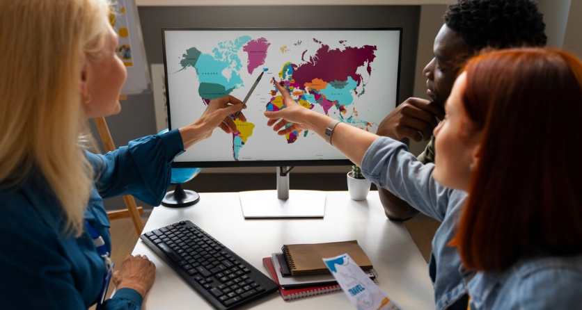 Team analyzing a world map on a computer screen.