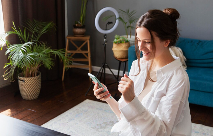 Woman celebrating while using her smartphone at home.