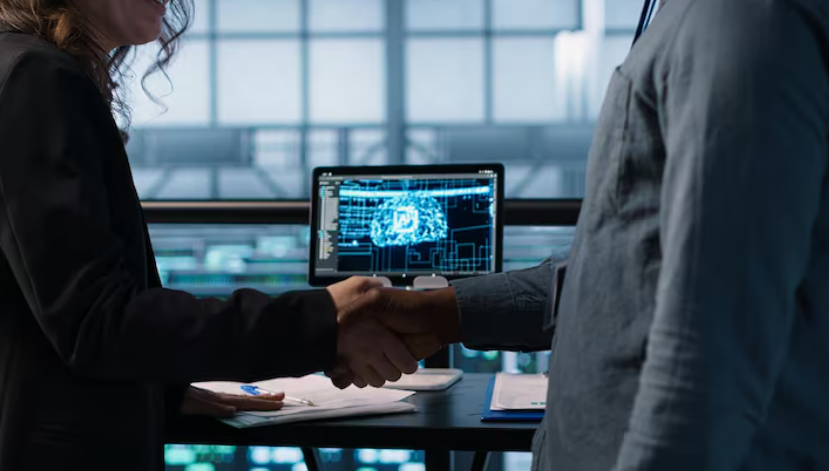 Two people shaking hands in office