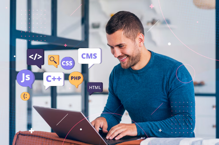 Smiling man coding on laptop with programming icons