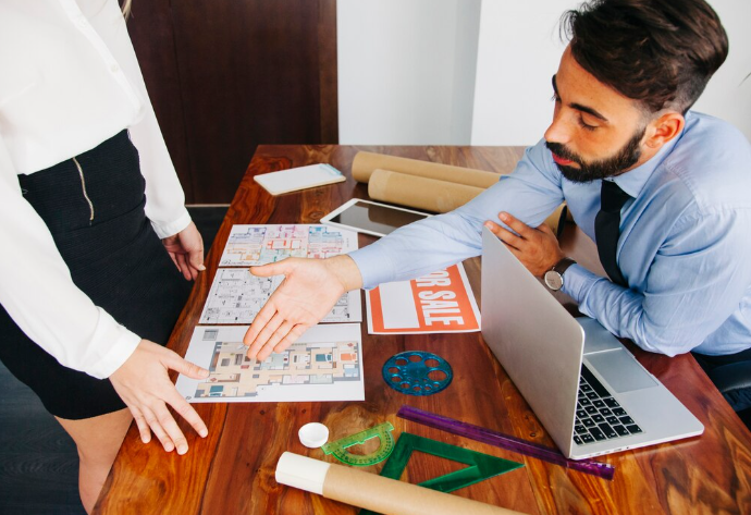 Real estate agent discussing floor plans with client