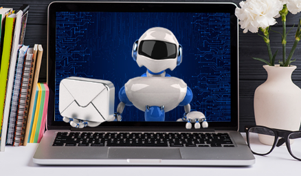 Cartoon robot holding an envelope appearing on a laptop screen, symbolizing email automation.
