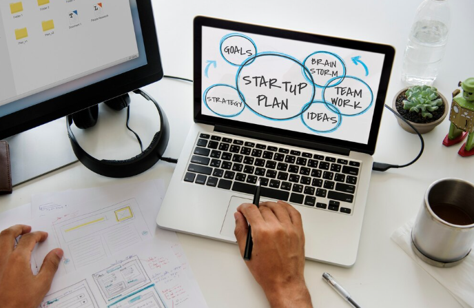 Laptop screen displaying startup plan with brainstorming and strategy notes.