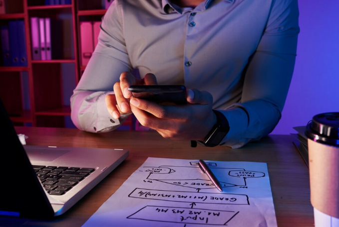 Man working on mobile app design at desk.