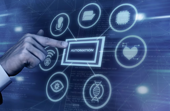 Hand pointing at automation icon with digital technology symbols.