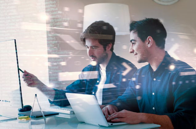 Developers collaborating on software project with laptops.
