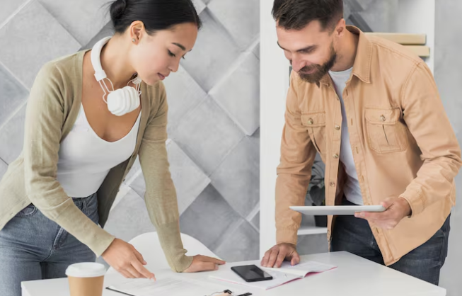Two colleagues reviewing documents and planning project together.
