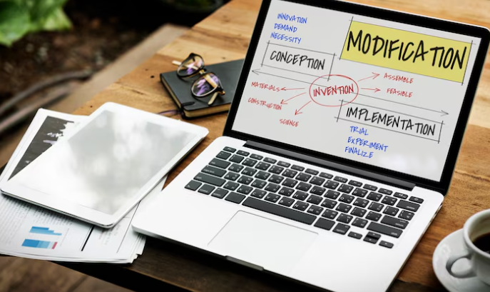 Laptop showing workflow chart of invention, conception, implementation, and modification.