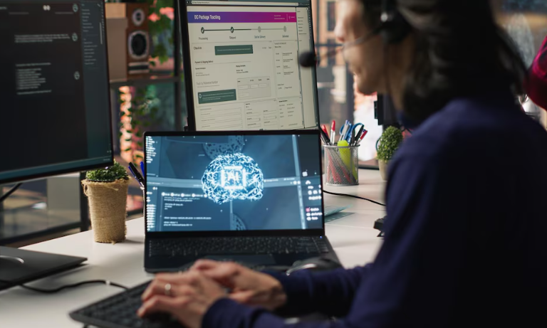 A person working on a laptop with AI and data-related visuals on multiple monitors.