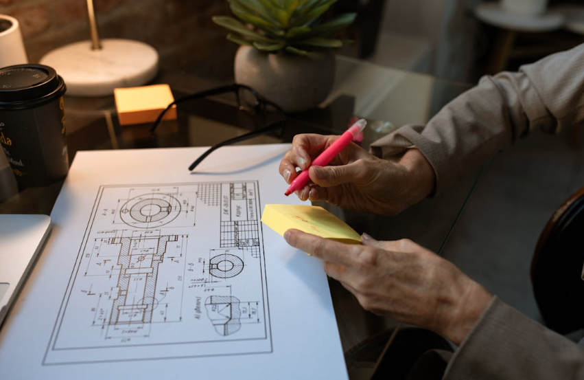 Person sketching on blueprint with notes