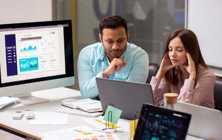 Colleagues reviewing analytics dashboard and brainstorming project performance.