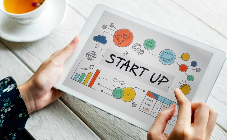 Hands holding tablet showing colorful startup planning sketches.