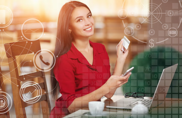 Smiling woman holding credit card while shopping online using her laptop.