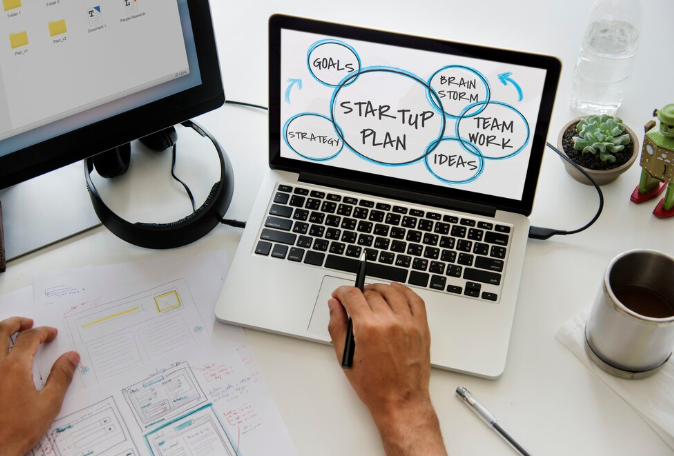 Laptop screen showing startup plan with brainstorming and teamwork ideas.