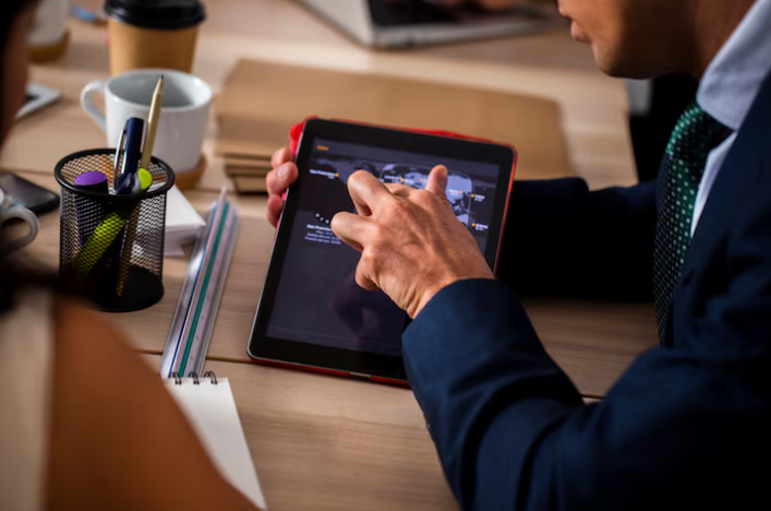 Businessman using a tablet for presentation in office meeting.