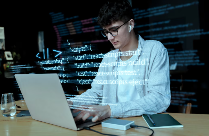 Person coding on laptop with headphones