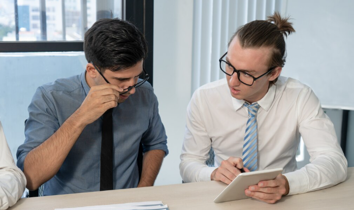 Two men discussing over tablet