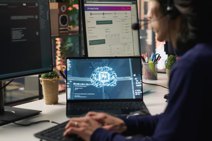 Person working on multiple computer screens.