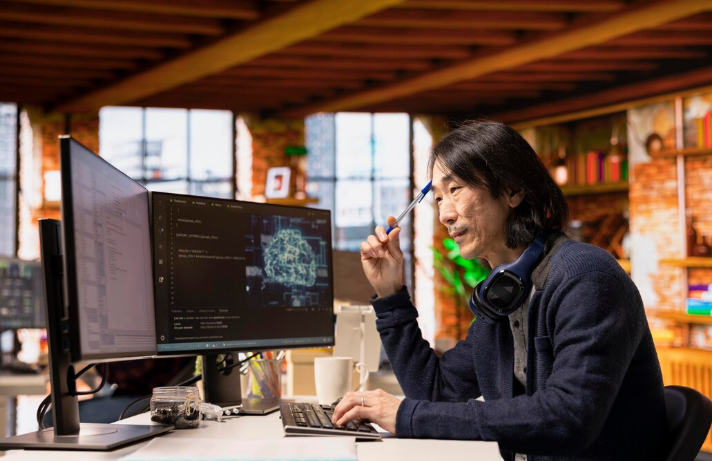 Programmer analyzing AI models and writing code at his desk.